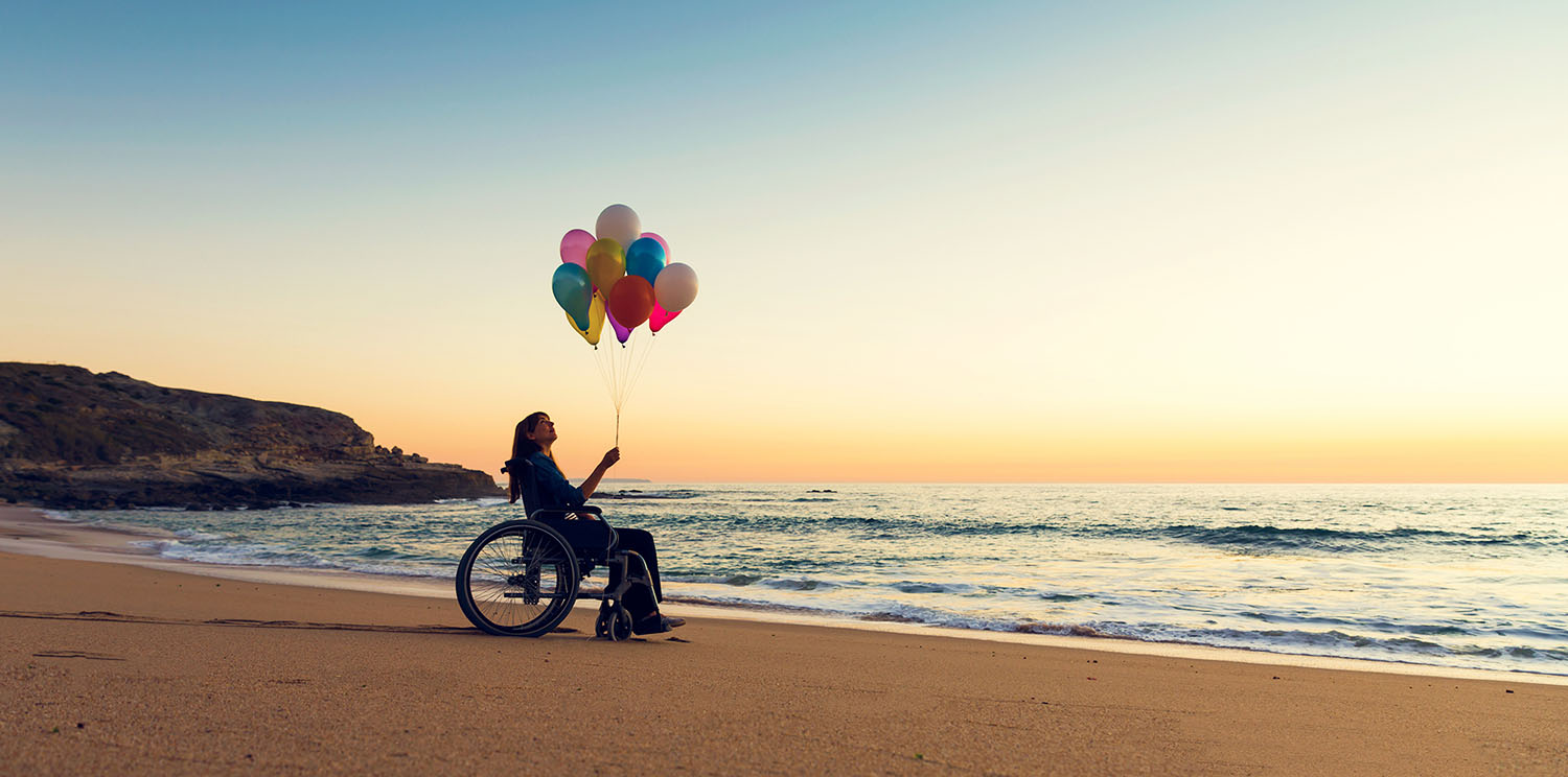 カラフルな風船を持っている車椅子の障がい者女性